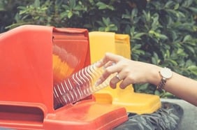 Woman-Drop-Plastic-Bottle-Into-recycling-1