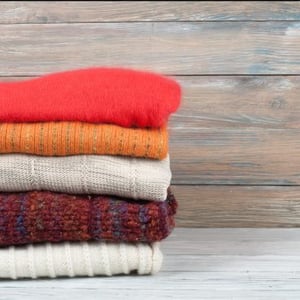 colourful clothes fibres stacked on a wooden background colourful clothes fibres stacked on a wooden background